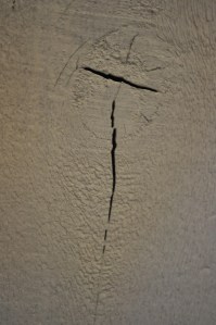 We are in the process of converting the 1970s cowboy-themed basement family room into Dave's and my bedroom (with office space for me!). When Dave painted all the rough wood, this crack-- in the shape of a cross--emerged! 